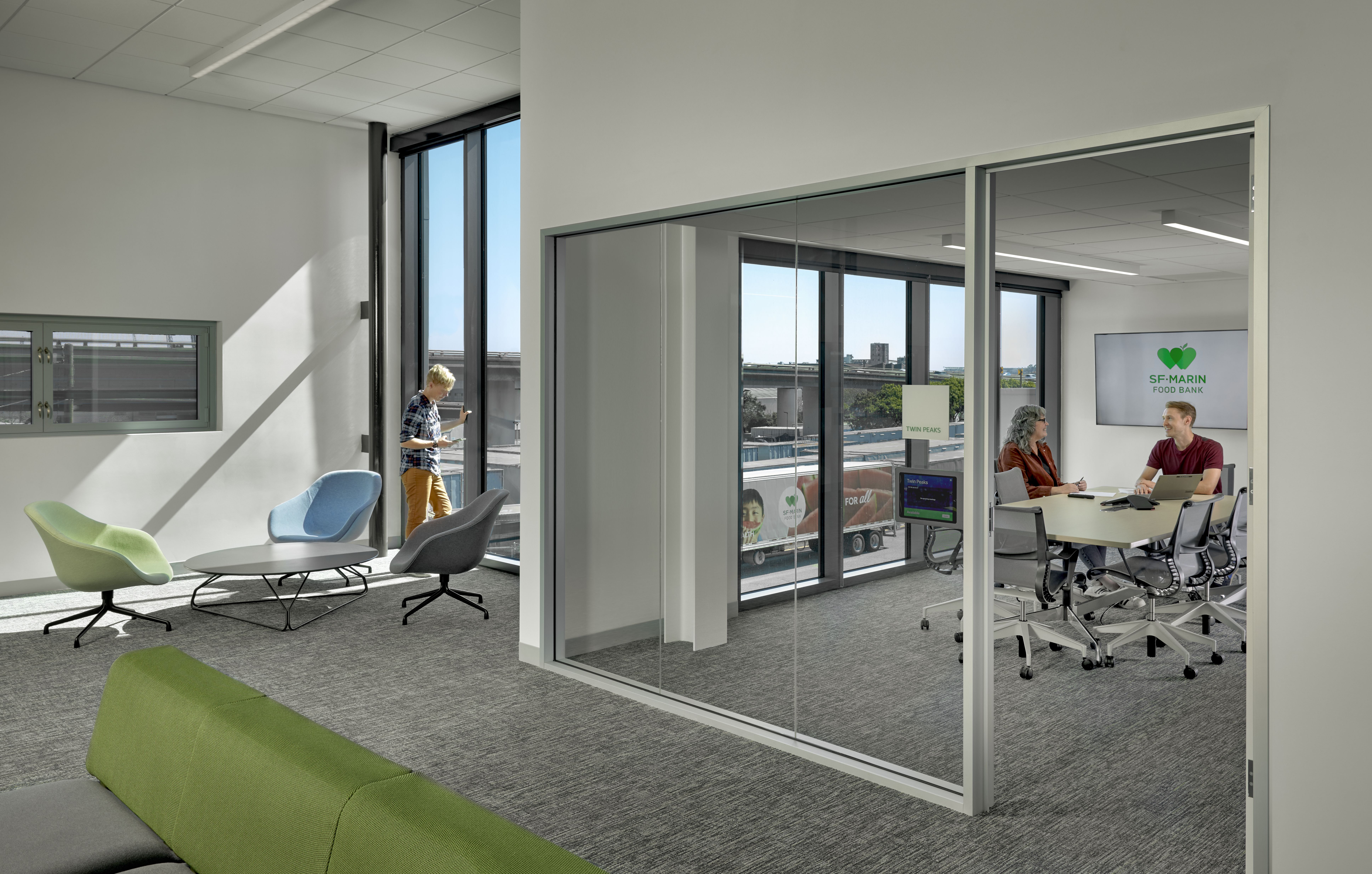 Conference room with two people seated at table.