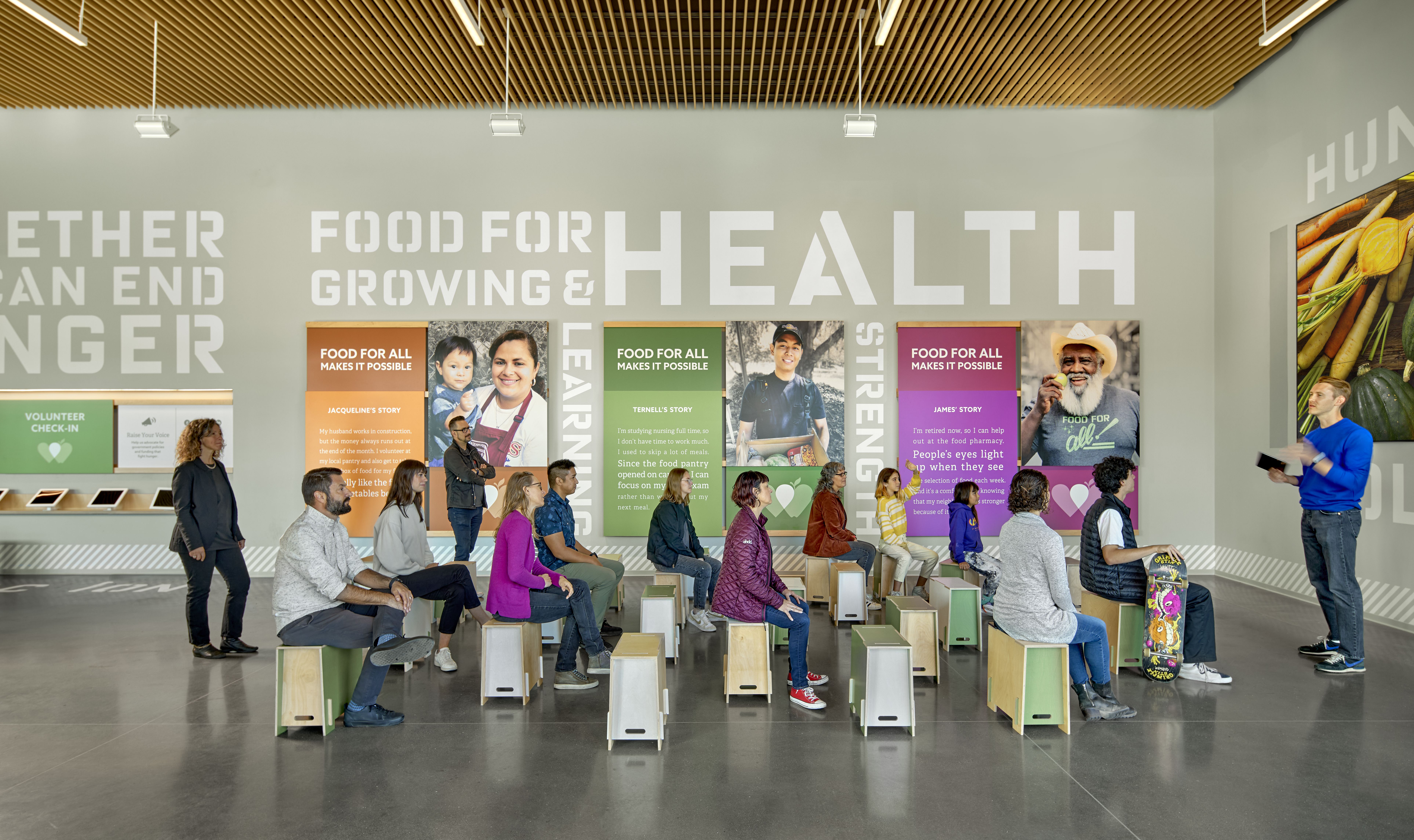 Interior gathering area with group of people and banners that say food for growing and health