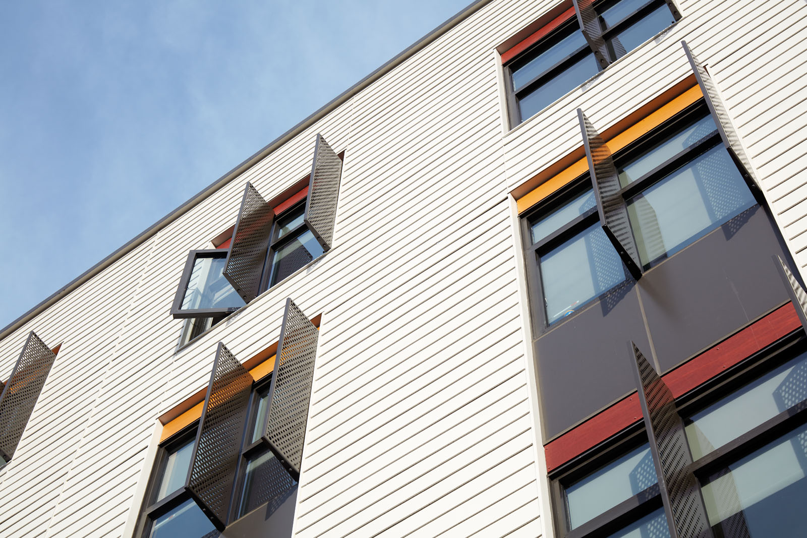 Close up exterior view of windows looking up from street with architectural window details.