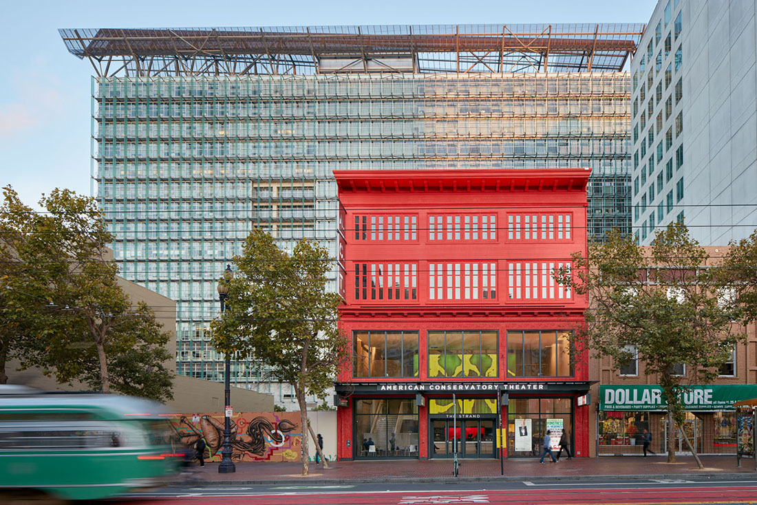 Wide view of façade along market street with street car passing in the foreground