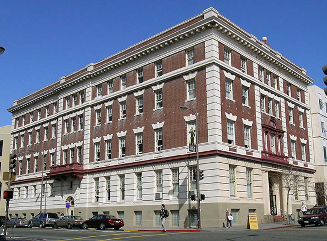 Exterior daytime corner view of ornate, historic, five-level red brick structure