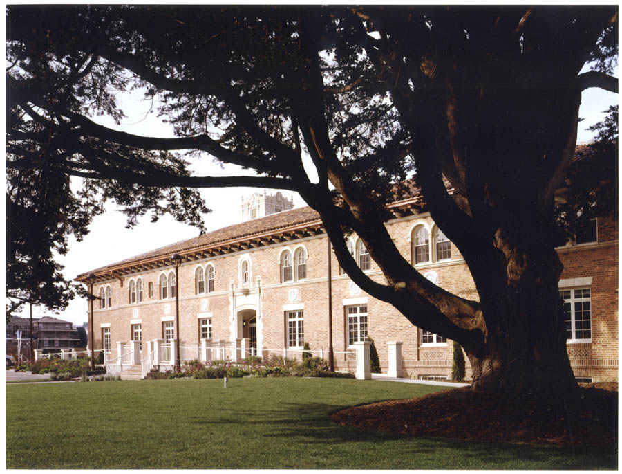 Exterior facade of historic brick building with tree in front.