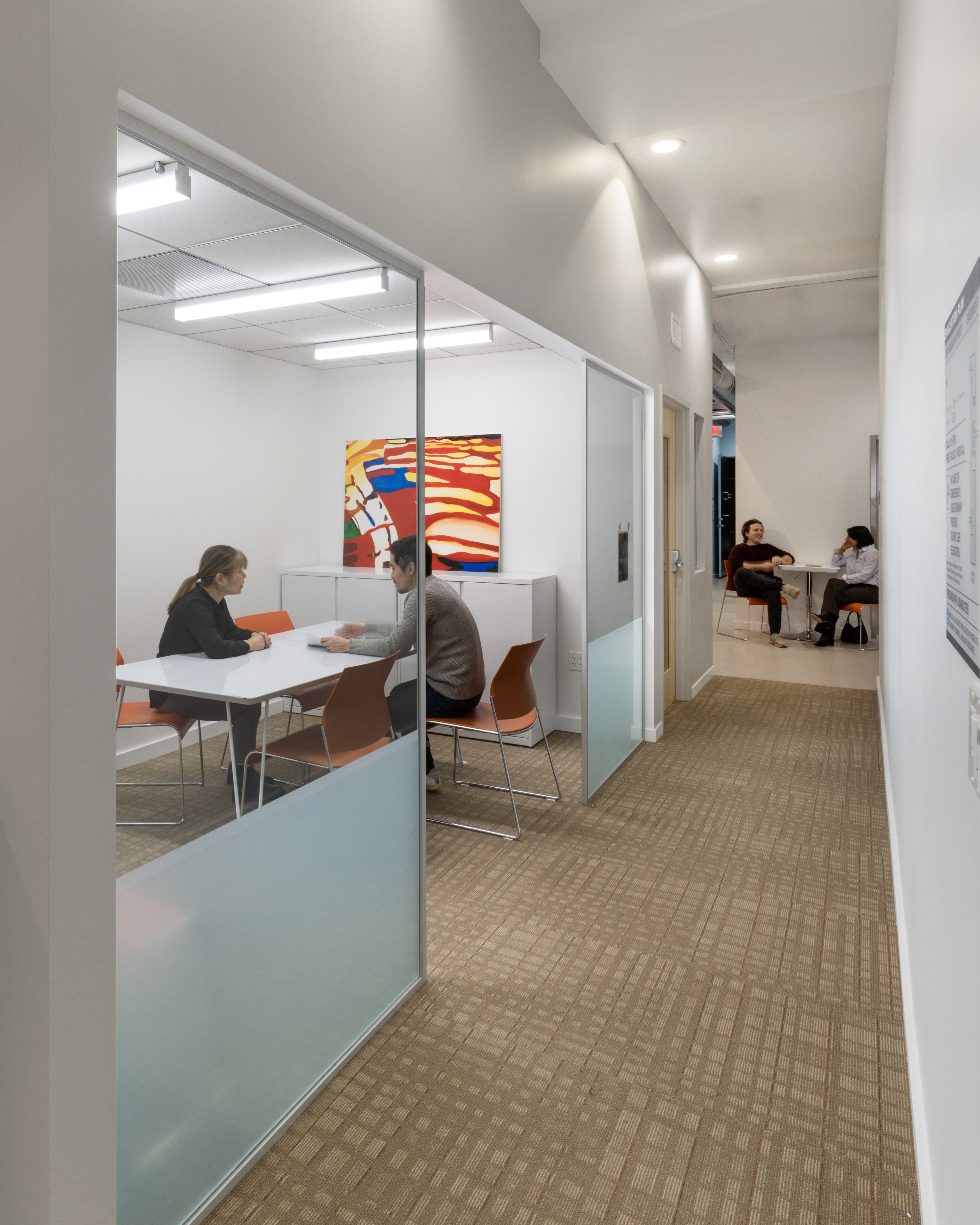 Hallway view to open space with semi-private meeting area