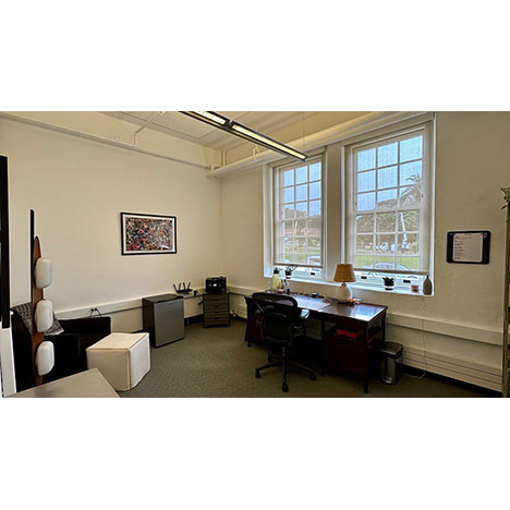 Image of interior of office with two windows, furnished with desk (not included in lease)