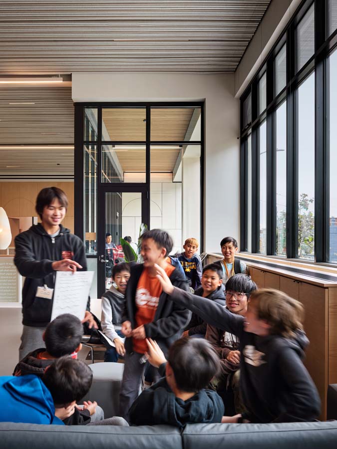 Students conversing in common area with benches.