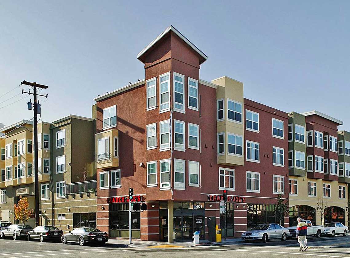 Exterior daytime corner view of multifamily units above Trader Joe's ground floor retail