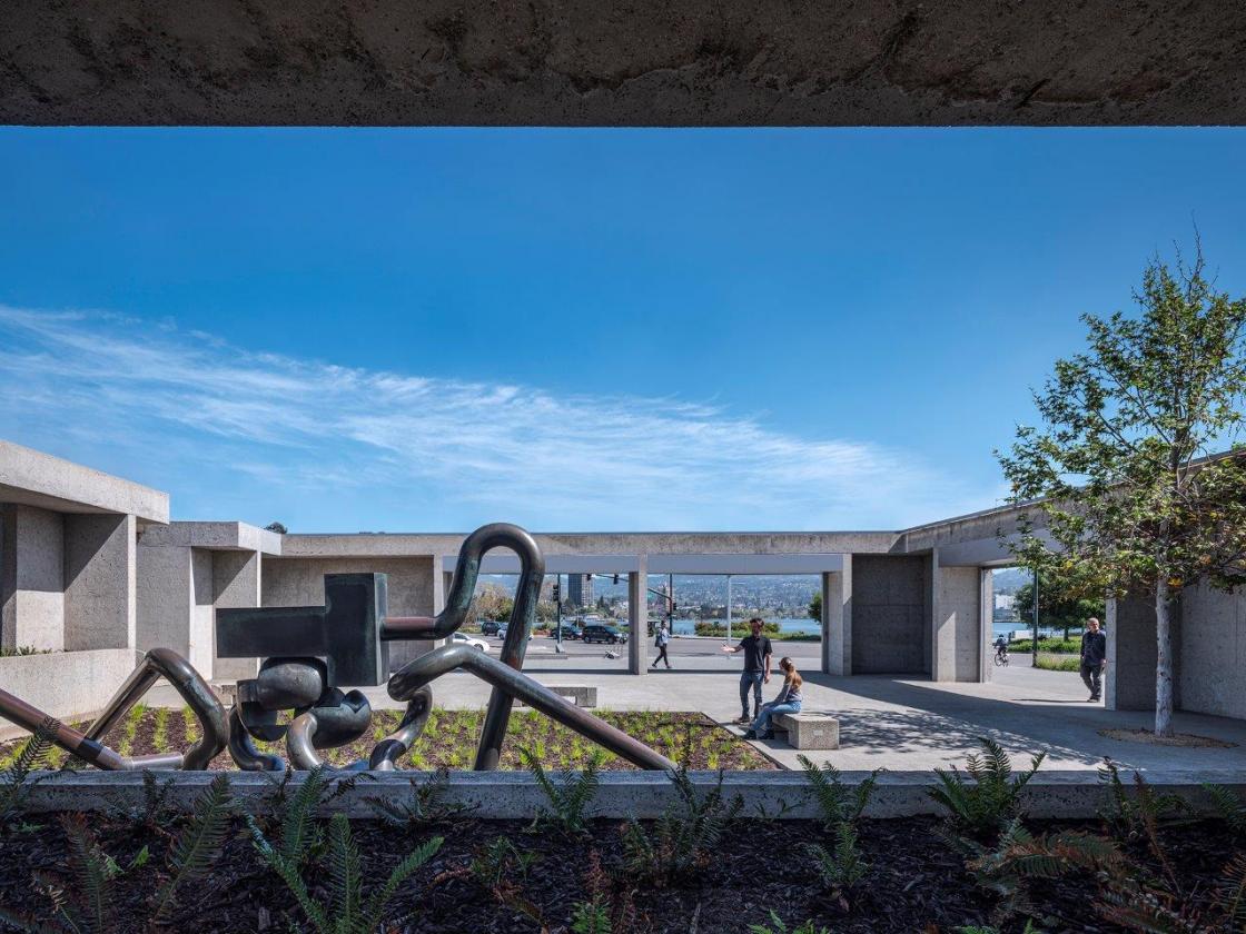 Museum exterior and scuplture with people in courtyard.