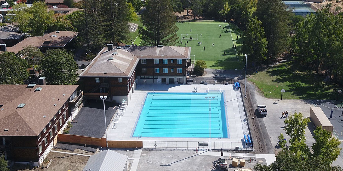 Aerial view of pool with soccer field in background.