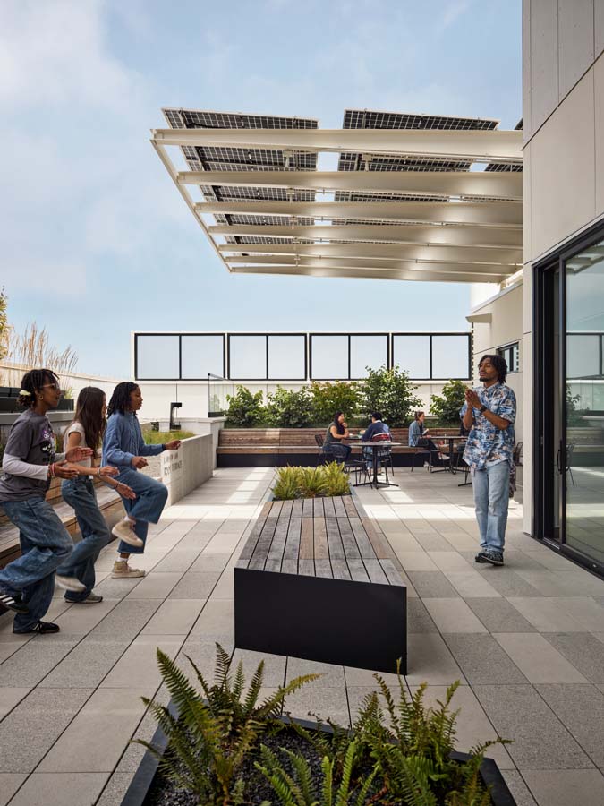 Exterior roof showing students sitting near planters.