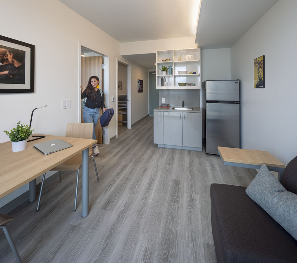 student apartment licing area showing table, couch and kitchenette