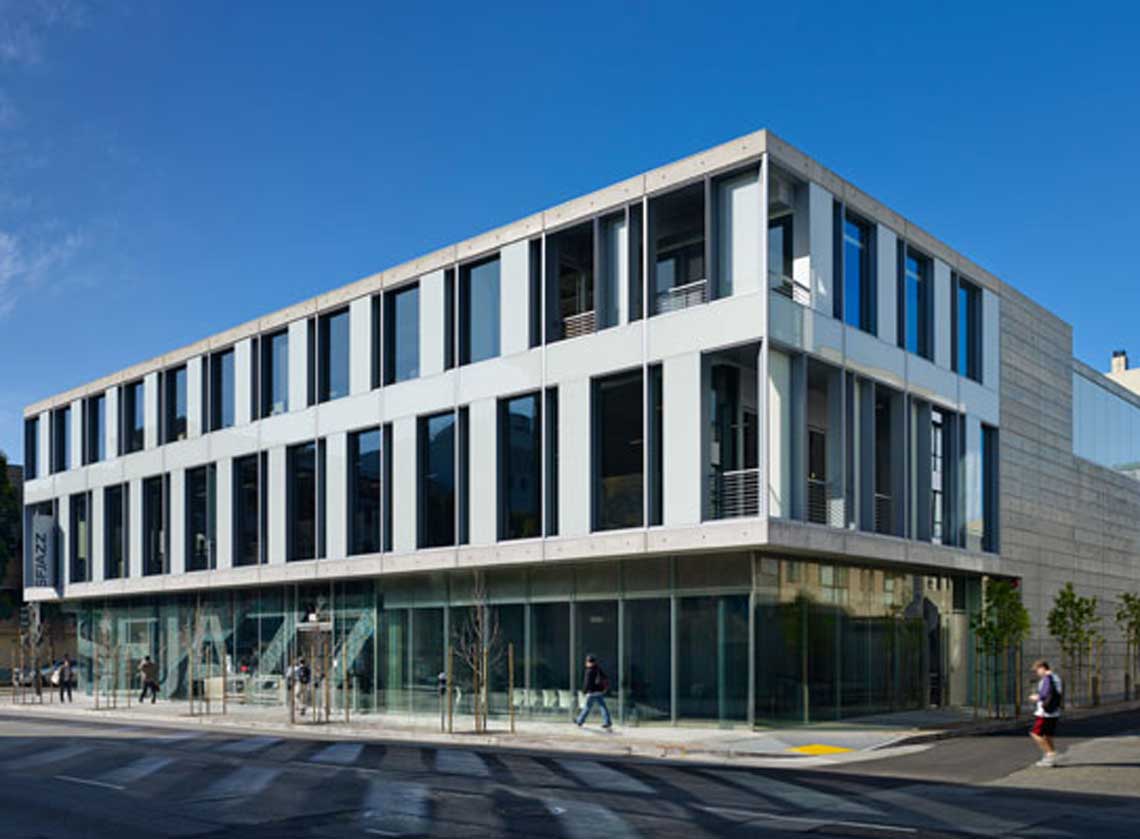 Exterior view of corner of building with modern architecture and donor recognition graphics on ground floor windows