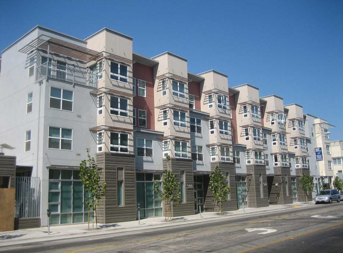 Exterior daytime view of multifamily units with architectural details and a variety of wall colors