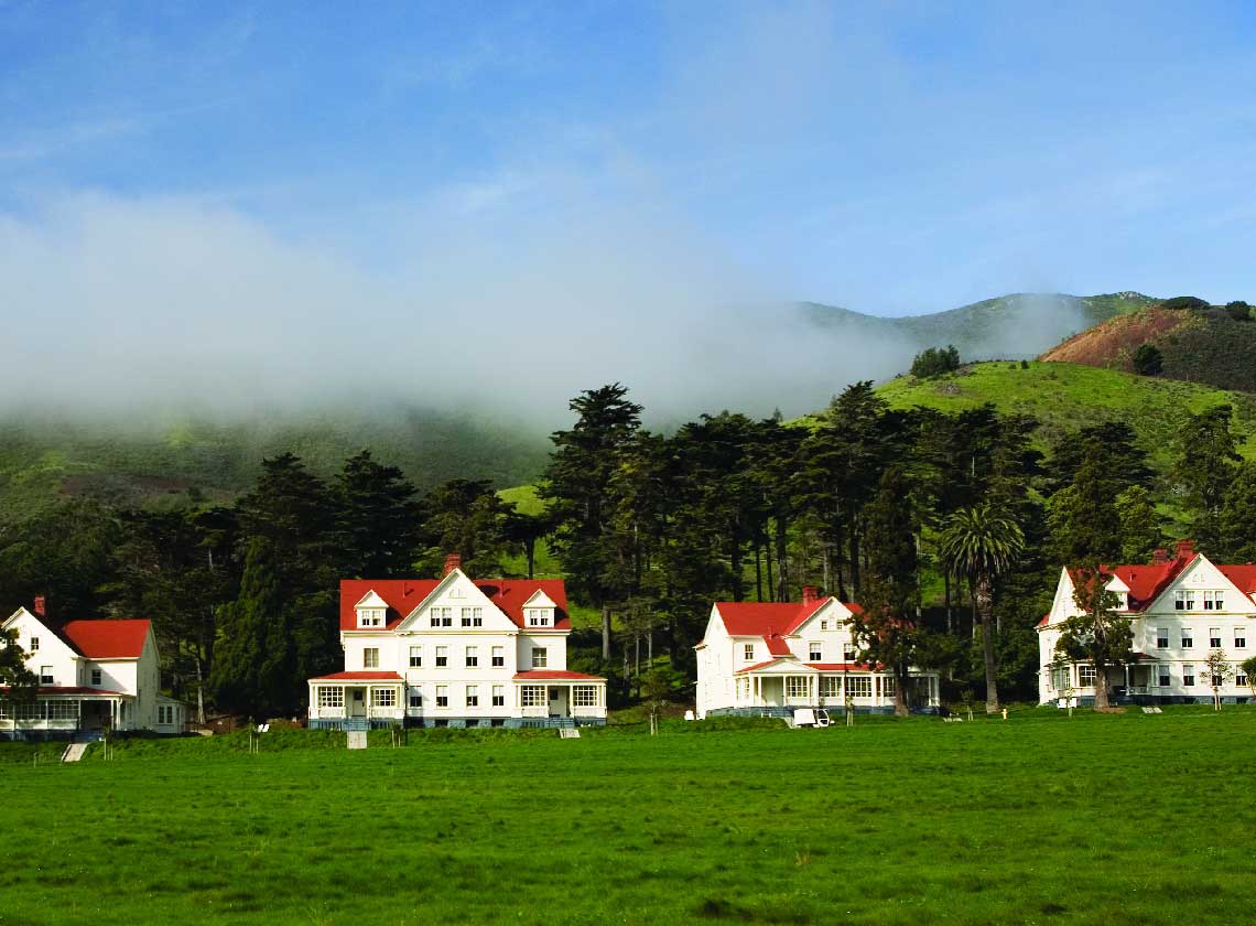 Exterior of historic lodge buildings with great lawn in the foreground.