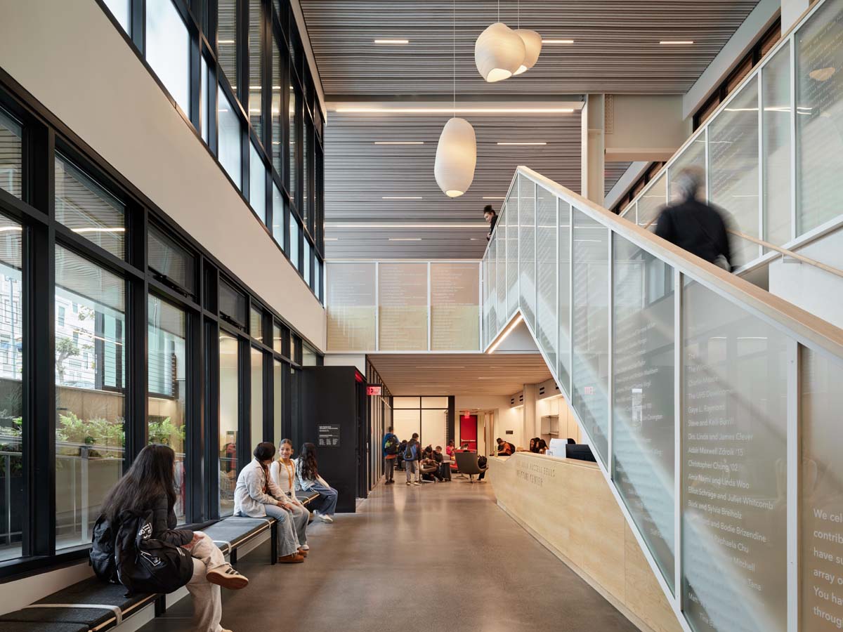 upward view of interior staircase showing benches below with students sitting.