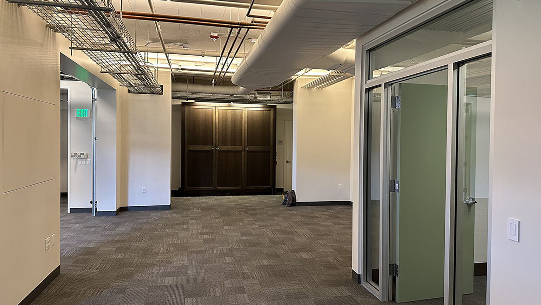 Photo of interior office space unfurnished showing entrance to private office