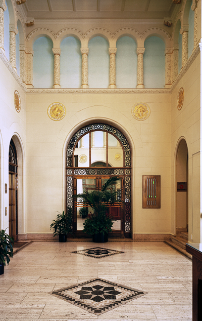 Interior image of lobby with historic marble floors, arches, and architectual details.
