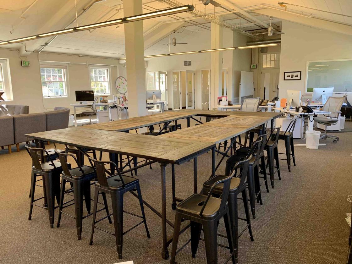 open office area with large rectangular conference table and chairs