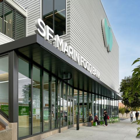 View of exterior of building from sidewalk with logo and SF Marin Food Bank above glass front entrance.