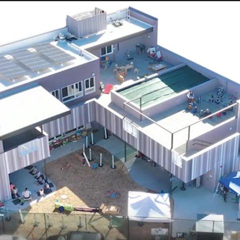 Aerial view of two story building looking down on play area.