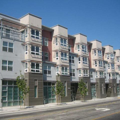 Exterior daytime view of multifamily units with architectural details and a variety of wall colors